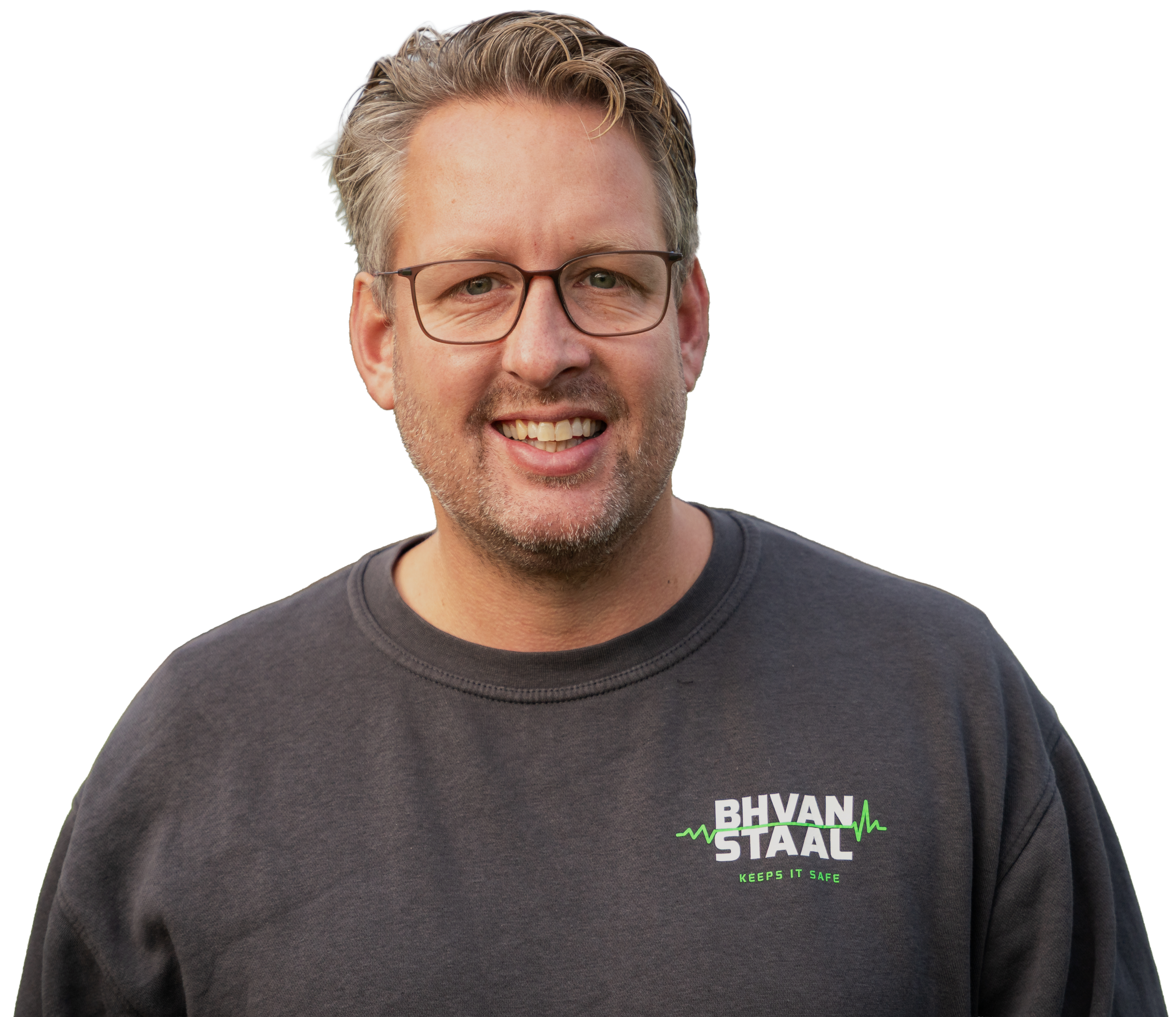 Portret van BHV-instructeur Eric Staal met grijze trui en glimlach, voor een neutrale achtergrond.